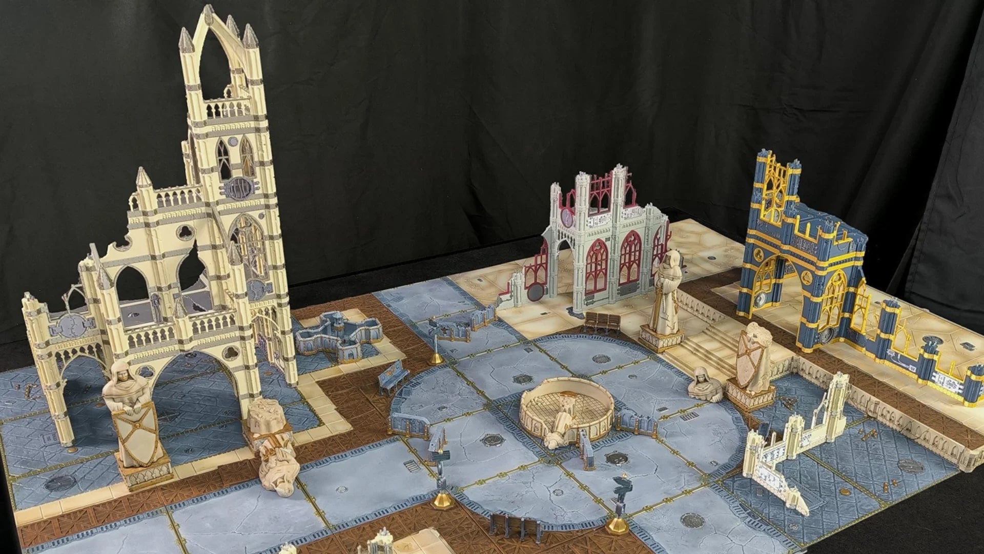 Décor de wargame imprimé en 3D, ruines médiévales et statues sur plateau de jeu.