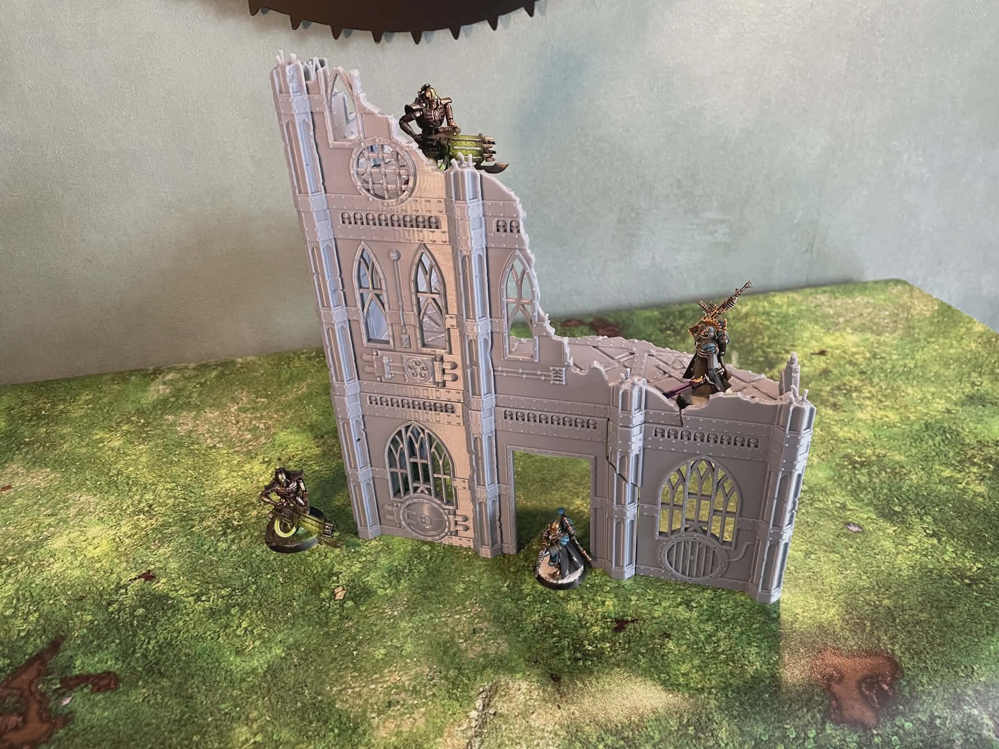 Décor wargame ruine gothique 3D avec figurines sur plateau de jeu vert
