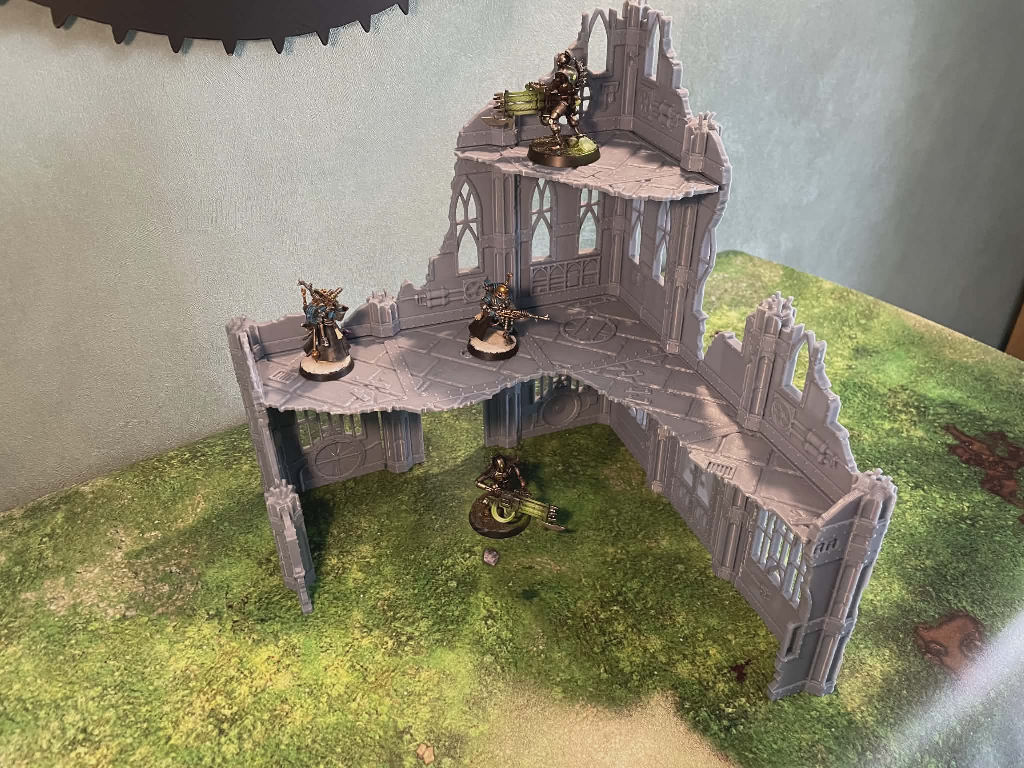 Décor ruine 3D pour wargame avec figurines, sur table de jeu herbeuse
